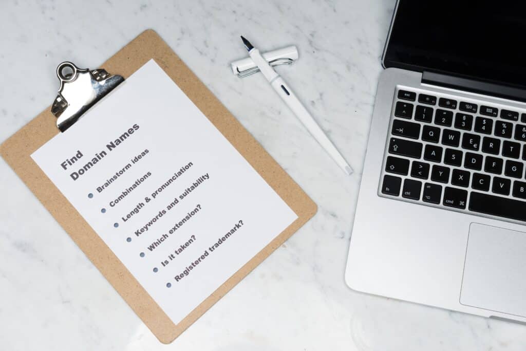 Image of a writing board with paper and a laptop