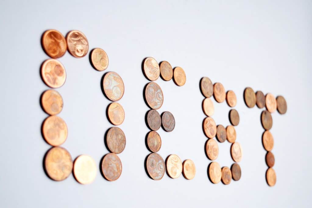 the word debt spelled out in coins